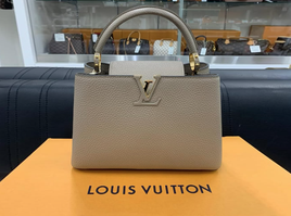 オレンジ色のボックスの上に置かれたLOUIS VUITTONのグレージュのハンドバッグ